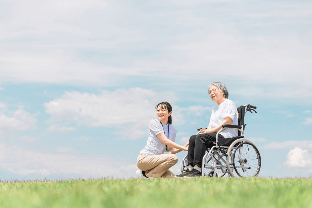 女性介護士と車いすに乗る高齢者