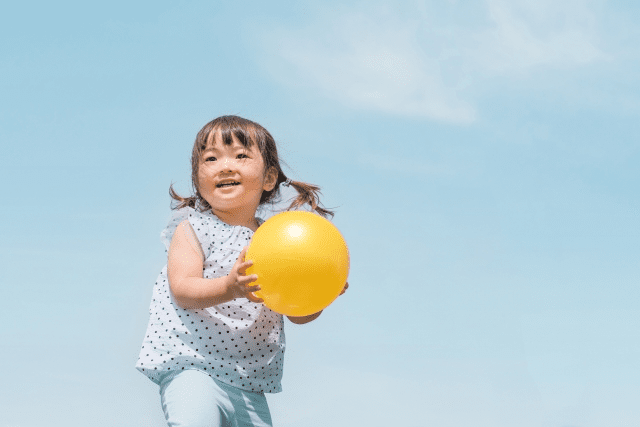 黄色いボールで遊ぶ子ども